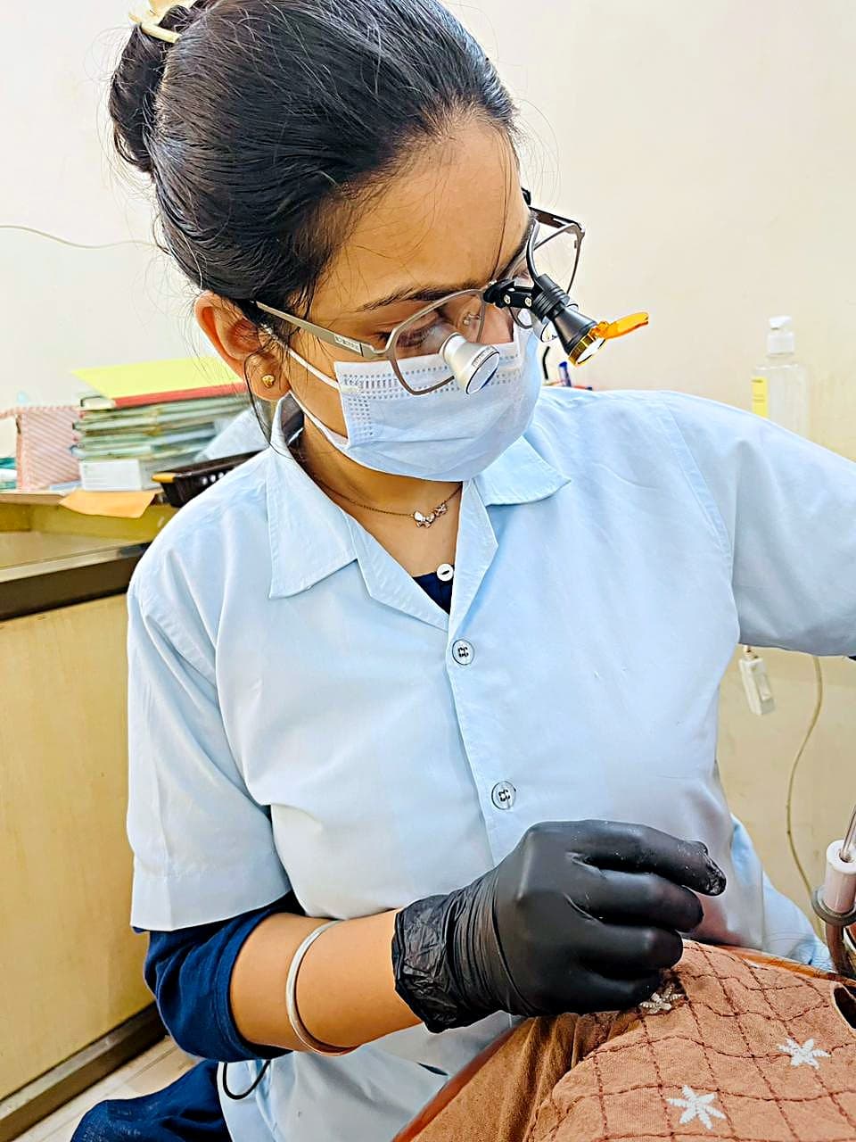 Dr. Bhavya Soni, root canal specialist, treating a patient under dental magnification loupes in Ahmedabad